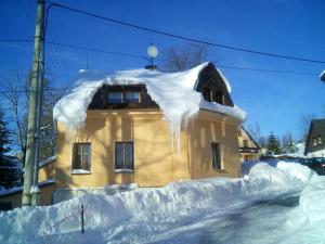 a building covered in snow next to a street at Kutloch u Trpoše in Pernink
