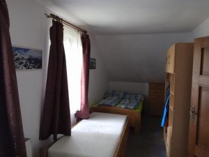 a small room with a bed and a window at Kutloch u Trpoše in Pernink