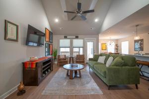 a living room with a green couch and a table at Back 40 Homestead - Trailside Basecamp in Bella Vista