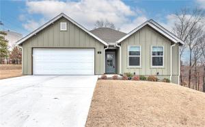 a large house with a white garage at Back 40 Homestead - Trailside Basecamp in Bella Vista