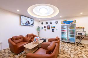 a waiting room with leather furniture and a large chandelier at Royal BJ Hotel in Pattaya South
