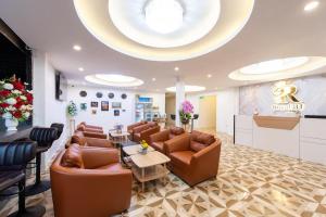 a waiting room with leather furniture and a large ceiling at Royal BJ Hotel in Pattaya South
