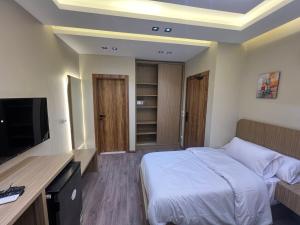 ein Hotelzimmer mit Bett und Flachbildfernseher in der Unterkunft Aman Villa in New cairo