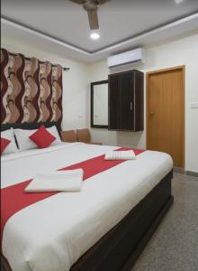 a bedroom with a large bed with red pillows at Metro Lodge in Chikmagalūr