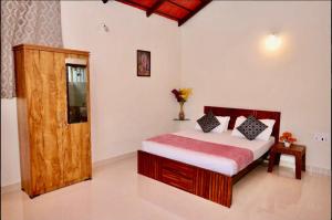a bedroom with a bed with a wooden door at Metro Lodge in Chikmagalūr