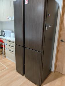 a black refrigerator in a kitchen next to a counter at わんぱくポケット in Tenjin
