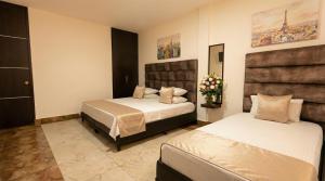 ein Schlafzimmer mit zwei Betten und Blumen darin in der Unterkunft Hotel Estevez in Chinácota
