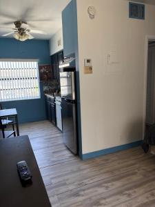 a kitchen with a refrigerator and a table in a room at OCEANS 735 of DEERFIELD BEACH in Deerfield Beach
