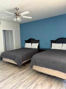 two beds in a bedroom with a blue wall at OCEANS 735 of DEERFIELD BEACH in Deerfield Beach +64 photos