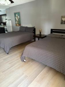 a bedroom with two beds and a wooden floor at OCEANS 735 of DEERFIELD BEACH in Deerfield Beach
