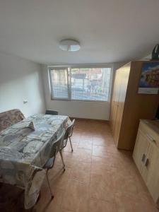 a living room with a table and a window at къща за гости ЕЛИАНИ in Gabrovo