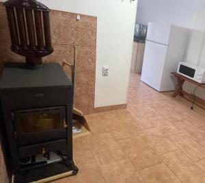 a stove in a living room with a refrigerator at къща за гости ЕЛИАНИ in Gabrovo +1 photo