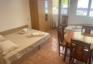 a room with two beds and a table and a table and chairs at къща за гости ЕЛИАНИ in Gabrovo