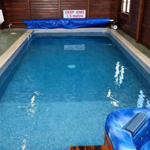 a pool of blue water with a sign in it at Wild Thistle static Caravan in Kirkcolm