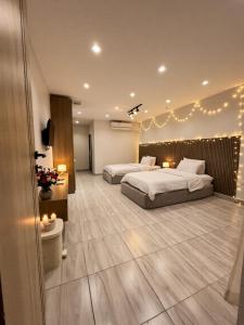 two beds in a room with lights on the wall at pyramids shadow inn hotel in Cairo