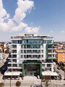 a large white building in a city with a parking lot at THE ONE CAORLE - Hotel & Apartments in Caorle