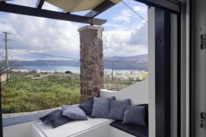 a white couch sitting in front of a window at Aelia Suites Akrotiri, Santorini in Akrotiri +23 photos