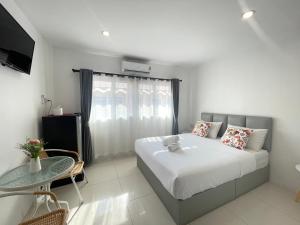 a bedroom with a large bed and a table at Royal BJ Hotel in Pattaya South