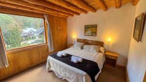 a bedroom with a bed and a large window at Apart Hotel del Pellin in San Martín de los Andes