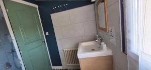 a bathroom with a sink and a green door at SarahScope - chambre cosy avec salle de bain privée proche Futuroscope in Saint-Georges-lès-Baillargeaux