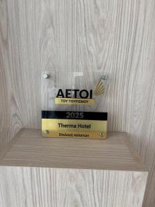 a stack of books sitting on top of a wooden shelf at Therma Hotel in Loutra Ipatis
