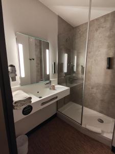 a bathroom with a sink and a shower at B&B HOTEL Clermont-Ferrand Nord Riom in Riom +32 photos