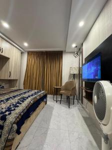 a bedroom with a bed and a flat screen tv at Stayease in Lahore