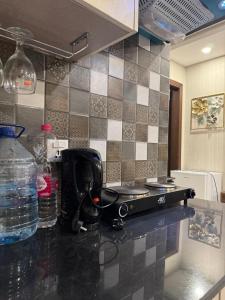 a kitchen counter with a sink and a bottle of water at Stayease in Lahore +10 photos