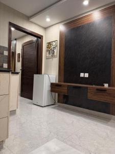 a kitchen with a refrigerator and a chalkboard on the wall at Stayease in Lahore