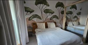 a bedroom with a bed with a mural of trees at Les Grands Cedres D3 in Nice