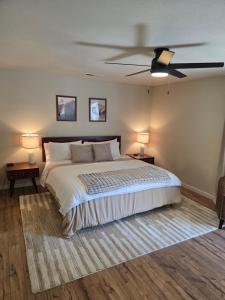 a bedroom with a large bed with a ceiling fan at Spacious Ranch Retreat Near Yosemite & Bass Lake with Hot Tub & Game Room in Oakhurst