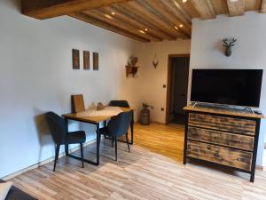 a dining room with a table and a flat screen tv at Vorderwahllehen in Schönau am Königssee