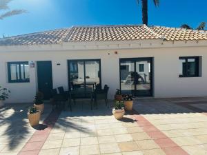 a white house with a patio with a table and chairs at Ferienhaus direkt am Strand mit Terrasse und Meerblick in Torrevieja in Punta Prima