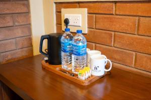 a table with two bottles of water and two cups at Brilliant View Cottages in Ella