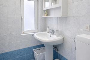 a white bathroom with a sink and a window at La casa di Sally - Silenzioso Bilocale in centro in Trieste +5 photos