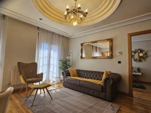 a living room with a couch and a mirror at Suite Legio VII in León