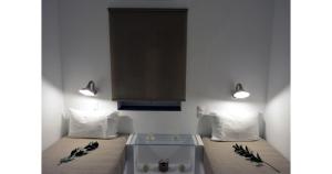 a room with two beds and two lights on the wall at Pier's House in Pollonia