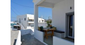 a balcony with a wooden table on a white building at Pier's House in Pollonia