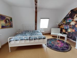 a bedroom with a bed and a chair and a rug at Ferienwohnung am Kloster in Hornbach