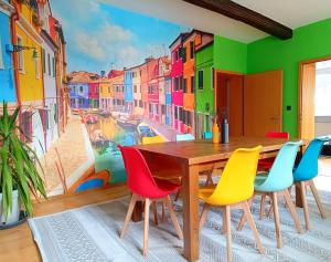 a dining room with a table and colorful chairs at Ferienwohnung am Kloster in Hornbach