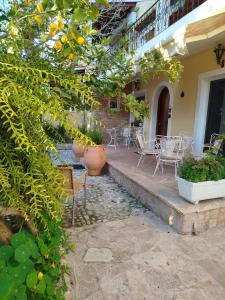 a patio with tables and chairs on a house at Athina's Mon Repo Apartment in Análipsis