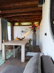 a dining room with a wooden table and a couch at B & B De Allee in Almelo