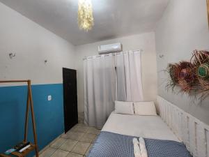 a small bedroom with a bed and a chandelier at Mini Hostel no centro de Tutoia in Tutóia +93 photos