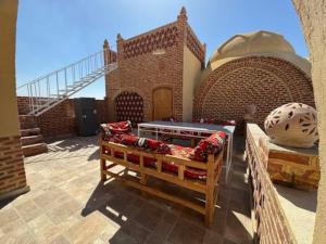 a patio with a couch in front of a brick building at Sahari house in Al Aqālitah