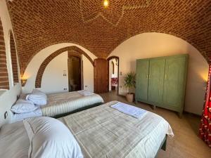 a bedroom with two beds and a brick wall at Sahari house in Al Aqālitah