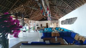 a large room with blue couches and a table at Nur Beach Hotel in Jambiani