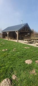 a large building with picnic tables in the grass at La Clé des Champs in Bertogne
