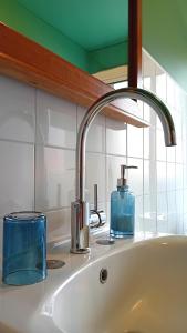 a bathroom sink with a blue soap dispenser on it at Faial Cottage in Cedros