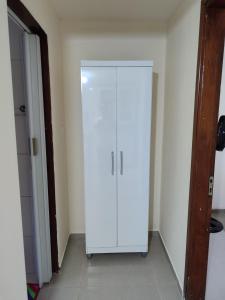 a white cabinet in the corner of a room at Kitnet 03 Lunardi Campinas in Campinas