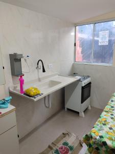 a white kitchen with a sink and a stove at Kitnet 03 Lunardi Campinas in Campinas